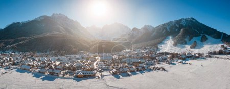 Kranjska Gora in Slovenia covered in snow at winter with Julian Alps and Triglav National Park in the background. Aerial Panorama