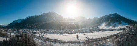 Téléchargez les photos : Kranjska Gora en Slovénie recouvert de neige en hiver avec les Alpes juliennes et le parc national du Triglav en arrière-plan. Panorama aérien - en image libre de droit
