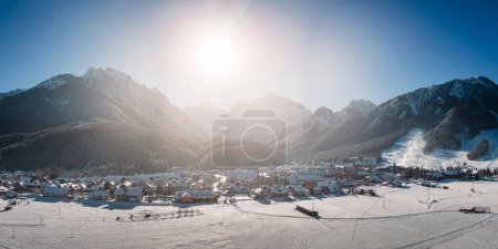 Foto de Kranjska Gora en Eslovenia cubierto de nieve en invierno con los Alpes Julianos y el Parque Nacional Triglav en el fondo. Panorama aéreo - Imagen libre de derechos