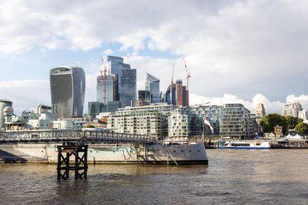 Téléchargez les photos : Londres, Royaume-Uni - 8 septembre 2022 - Vue sur les docks de Londres et le centre d'affaires de Canary Wharf avec des tours et des gratte-ciel modernes et un navire de la marine militaire - en image libre de droit