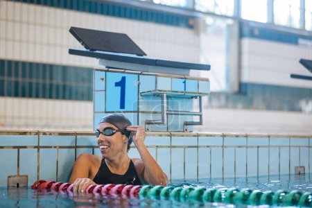Photo for Woman swimmer happy at the finish of a race in the pool at competition - Royalty Free Image