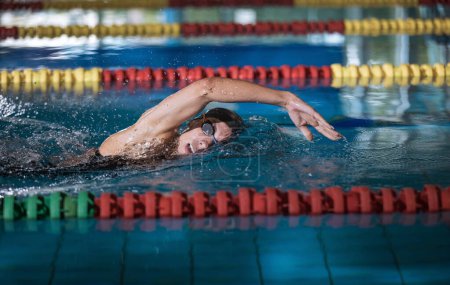 Professional female swimmer swimming the front crawl stroke. Freestyle competition concept.
