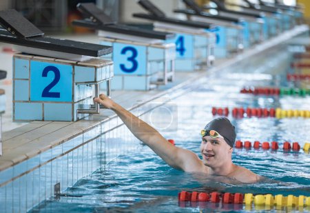 Photo for Man swimmer happy at the finish of a race in the pool at competition - Royalty Free Image