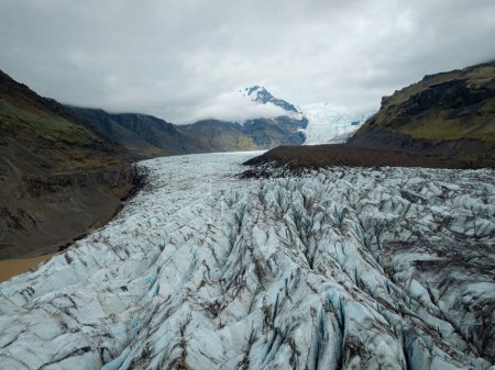 Dramático paisaje islandés de lengua glaciar brotando de la capa de hielo, con una pared glacial en el fondo en el sombrío día de invierno, tiro con drones.