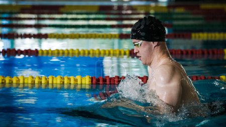 Hombre atleta nadando en estilo de pecho en la piscina, accidente cerebrovascular, inmersión, y levantar fuera del agua para respirar.
