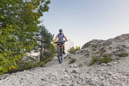Freizeitradler mit Elektro-Mountainbike auf weißem Schotterweg. EMTB-Radverkehrskonzept.