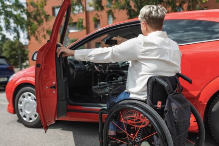 Photo for Female driver with disability entering a car, a wheelchair user on the way to work. Concepts of accessibility, transport, and safety. - Royalty Free Image