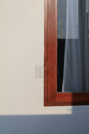 Téléchargez les photos : Coin de fenêtre en bois sous la lumière du soleil du matin fond mural blanc. Extérieur minimal. - en image libre de droit