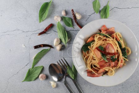 Spaghetti Bacon chili garlic basil in white plate on gray background. Popular menu classic italian cuisine dish. Delicious spicy food.