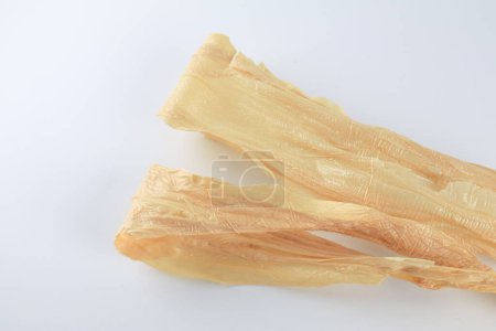 Dry tofu skin on white background. Traditional Asian meat substitute. Chinese food ingredients.