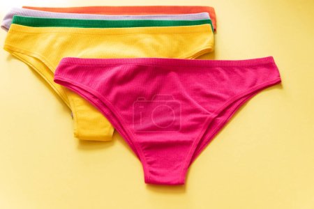 Photo for Set of colorful underpants on yellow background, close up. Cotton panties. Womens underwear. Top view - Royalty Free Image