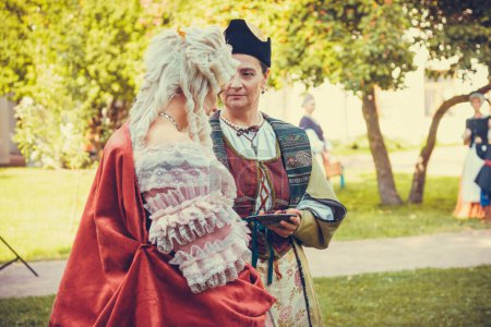 Portrait of two woman dressed in historical Baroque clothes with old fashion hairstyle, outdoors. Luxurious medieval dress