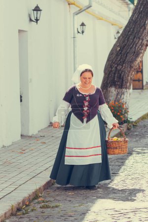 Foto de Retrato de mujer morena vestida con ropa barroca histórica con peinado de moda antigua, al aire libre. Vestido medieval de clase obrera - Imagen libre de derechos