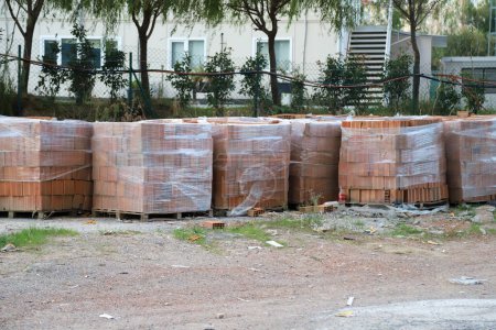 Photo for Orange clay block at construction site, Orange hollow brick, in pallet stacked, stretch-wrapped - Royalty Free Image
