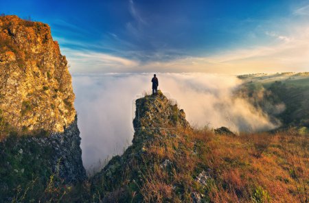 Kobieta stoi na skale nad kanionem rzeki. turystka cieszy się mglistym jesiennym krajobrazem. charakter Ukrainy