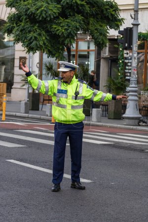 Photo for Police agent, Romanian Traffic Police (Politia Rutiera) directing traffic. Rush hour in Bucharest, Romania, 2022 - Royalty Free Image