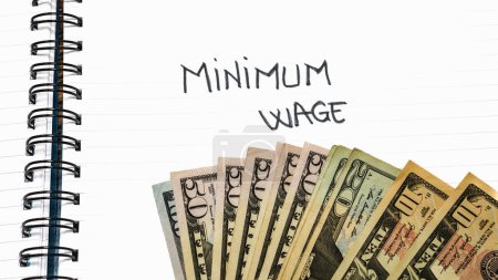 Minimum wage handwriting  text on paper, on office agenda. Copy space.