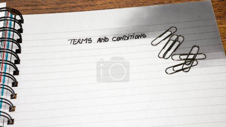 Foto de Términos y condiciones, texto de escritura a mano en la página de agenda de la oficina, cuaderno en espiral de la oficina. Copiar espacio
. - Imagen libre de derechos