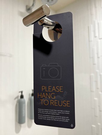 Photo for Reminder in a Courtyard Marriott hotel bathroom to hang towels for reuse in an effort to conserve water. - Royalty Free Image