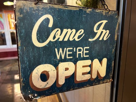 Téléchargez les photos : Vintage-looking sign on a store door that says Come In We're Open - en image libre de droit