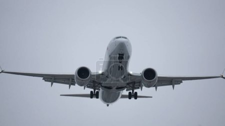 Téléchargez les photos : En regardant un Boeing 737 voler au-dessus de l'aéroport. - en image libre de droit
