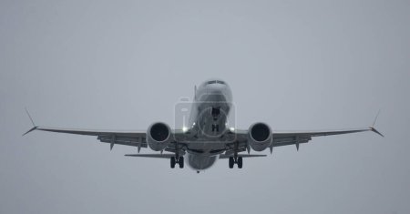 Téléchargez les photos : Looking up at a Boeing 737 flying overhead as it approaches the airport. - en image libre de droit