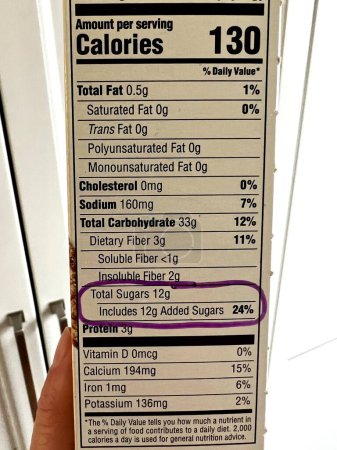 Téléchargez les photos : Étiquette nutritionnelle sur une boîte de céréales contenant 12 grammes de sucre ajouté. Les lignes directrices alimentaires pour les Américains pour les sucres ajoutés est de 50 grammes par jour sur la base d'une alimentation quotidienne de 2000 calories. - en image libre de droit