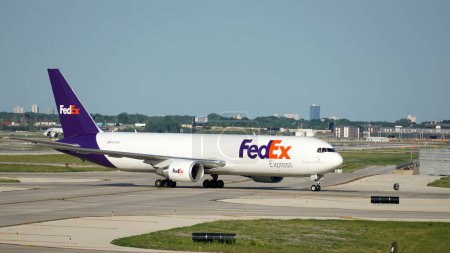 Foto de Chicago, IL, EE.UU. - 18 de julio de 2023: FedEx taxis de aviones de carga en la pista después de aterrizar en el Aeropuerto Internacional O 'Hare de Chicago. - Imagen libre de derechos