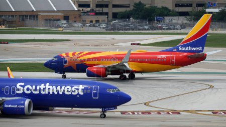 Téléchargez les photos : Les avions de Southwest Airlines - dont l'un avec la livrée Arizona One - se croisent en circulant sur la piste de l'aéroport international Midway de Chicago. - en image libre de droit