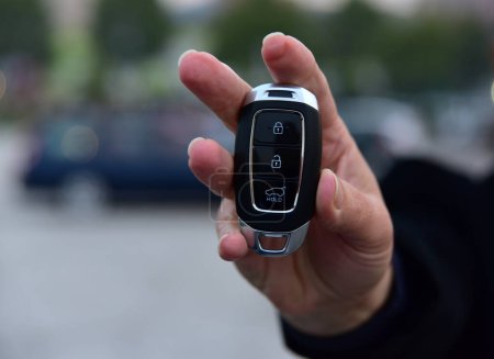 Téléchargez les photos : Une femme tient une clé de voiture pop-up dans sa main - en image libre de droit