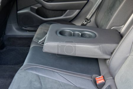 Armrest in the luxury passenger car with cup holder between the front seats