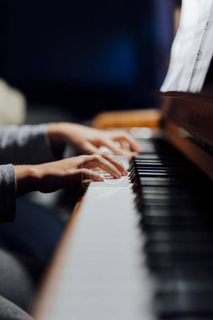 Téléchargez les photos : Pianiste dans une lumière abondante, vous ne pouvez voir les mains des joueurs qui pratique la leçon de piano. - en image libre de droit
