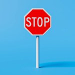 Stop sign standing on blue background. 3d rendering
