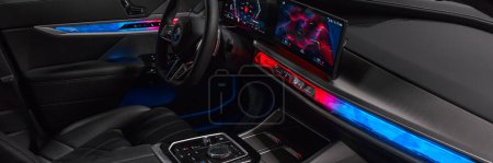 Photo for Interior and dashboard of a BMW 7 series with backlight in sport mode, view through open passenger door. BMW 7 Series, G70, a modern premium limousine. On sale from 2023. Poland, Katowice 03.05.2023 - Royalty Free Image