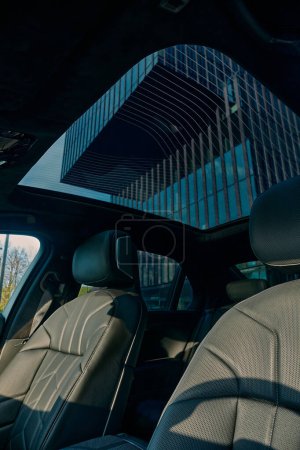 Photo for BMW 7 Series, G70, a modern premium limousine. From inside the car, a modern office building can be seen through the roof window. On sale from 2023. Poland, Katowice 03.05.2023 - Royalty Free Image