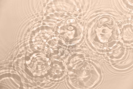 Téléchargez les photos : Fond d'eau douce. Motif avec texture claire de l'eau ondulée en beige, couleur neutre. Vue du dessus - en image libre de droit