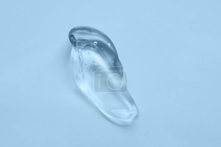 Cosmetic transparent gel on blue background. Skincare beauty hygiene product close-up