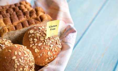 Glutenfreies Etikett auf einem Korb mit frisch gebackenem Brot und Brötchen. Kopierraum.