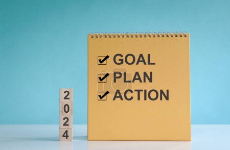 2024 goal, plan and action, words on wood block and calendar.