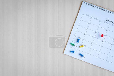 Foto de Calendario con alfileres rojos y coloridos, vista superior. Copiar espacio. - Imagen libre de derechos