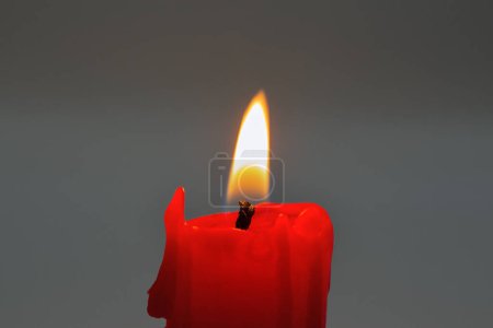 Foto de Quemadura pequeña vela roja stub primer plano sobre fondo oscuro - Imagen libre de derechos