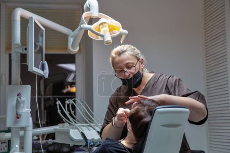 Foto de Kyiv, Ukraine - December 24, 2022: Dentist working with a patient in a dental office with different dental instruments and tools for treatment. - Imagen libre de derechos