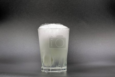 Téléchargez les photos : Dissolving instant effervescent tablets in a glass of water closeup on black - en image libre de droit