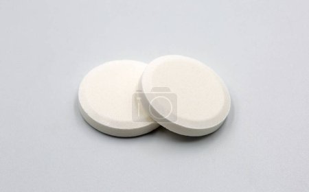 Téléchargez les photos : Multivitamin effervescent tablet pills closeup on white. Vitamin C soluble pills. Fizzy Vitamin C for drink. - en image libre de droit