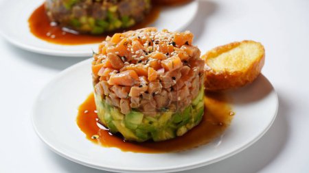 Raw Salmon tartar with avocado, and lemon hashed avocado, with spices, and sesame