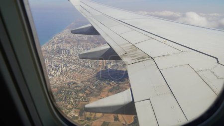 Foto de Ala de un avión volando sobre Israel, vista del pasajero. Mirando por la ventana de un avión en su ala brillante - Imagen libre de derechos