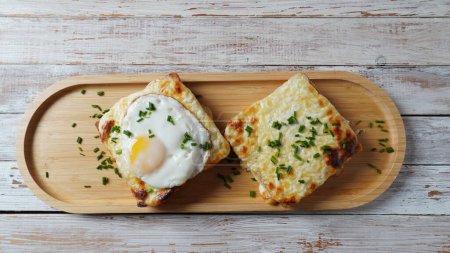 Hot French Traditional Croque madame and croque monsieur sandwiches for breakfast. Melted cheese and a fried egg