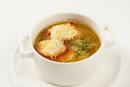 Una clásica sopa de cebolla francesa con queso gruyere y baguette tostada en un tazón