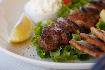 Photo for Souvlaki, meat skewers, traditional Greek  meat food on pita bread, tzatziki sauce and potatoes - Royalty Free Image