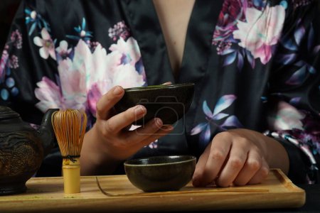 Photo for Woman tea master in kimono performs tea ceremony. Matcha green tea powder with a bamboo whisk and scoop as used in a traditional Japanese tea ceremony. - Royalty Free Image